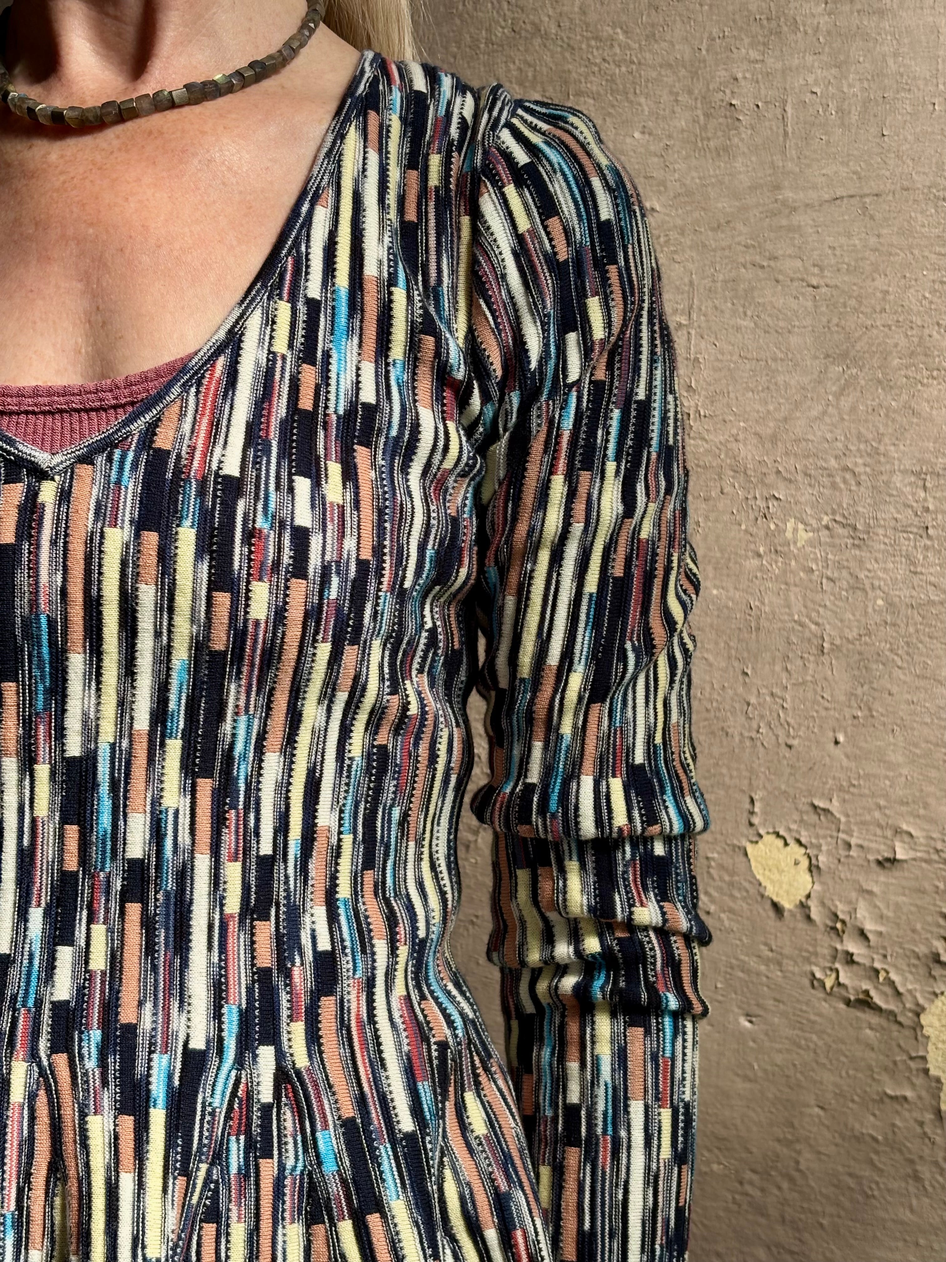 Mature woman wearing premium cotton ULLA JOHNSON Rosalia Peplum Knit Top Oasis long sleeves v-neck