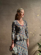Mature woman wearing premium cotton ULLA JOHNSON Rosalia Peplum Knit Top Oasis long sleeves v-neck