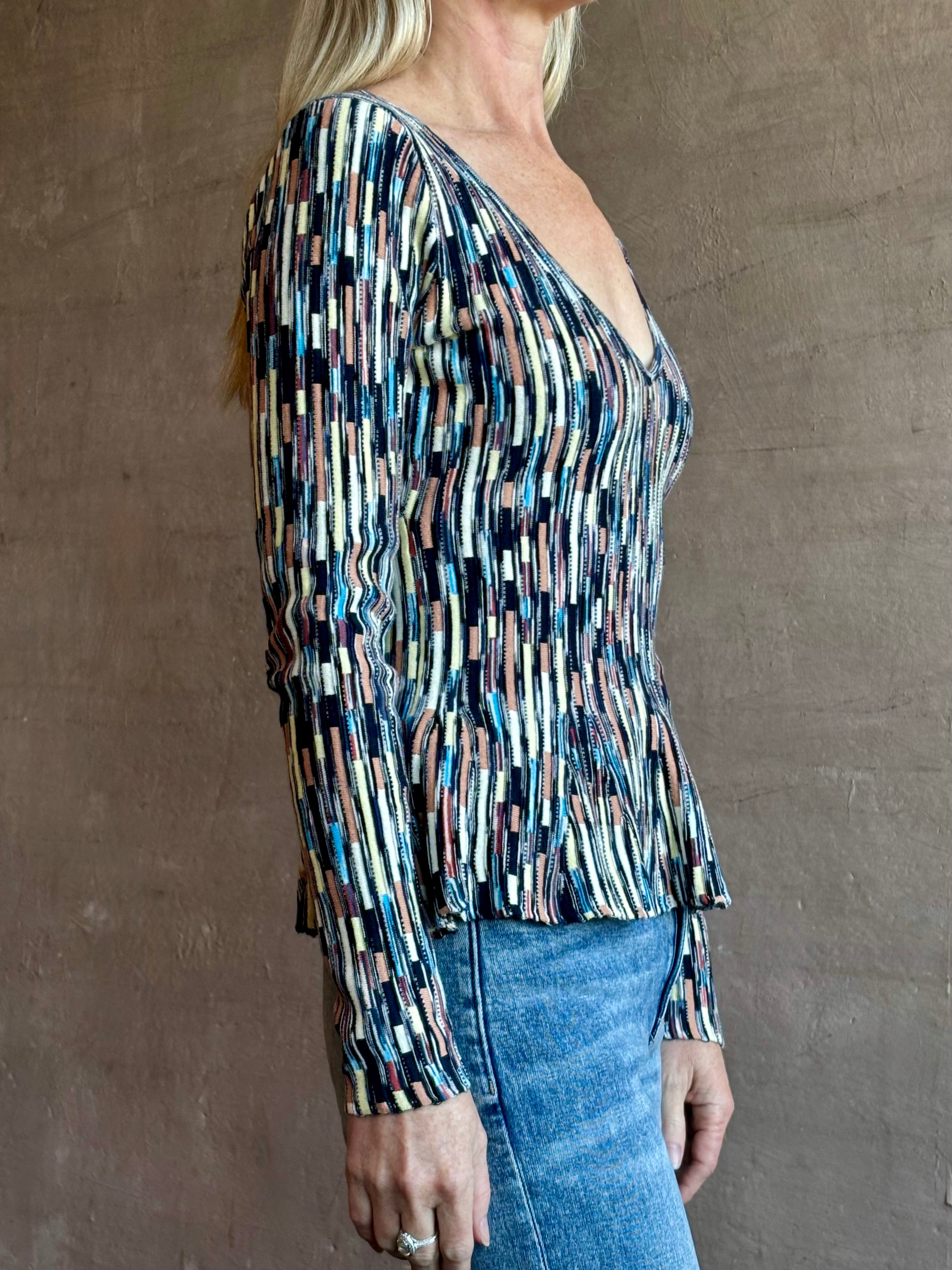 Image of woman wearing premium cotton ULLA JOHNSON Rosalia Pullover Peplum Knit Top in Oasis with long sleeves and v-neck