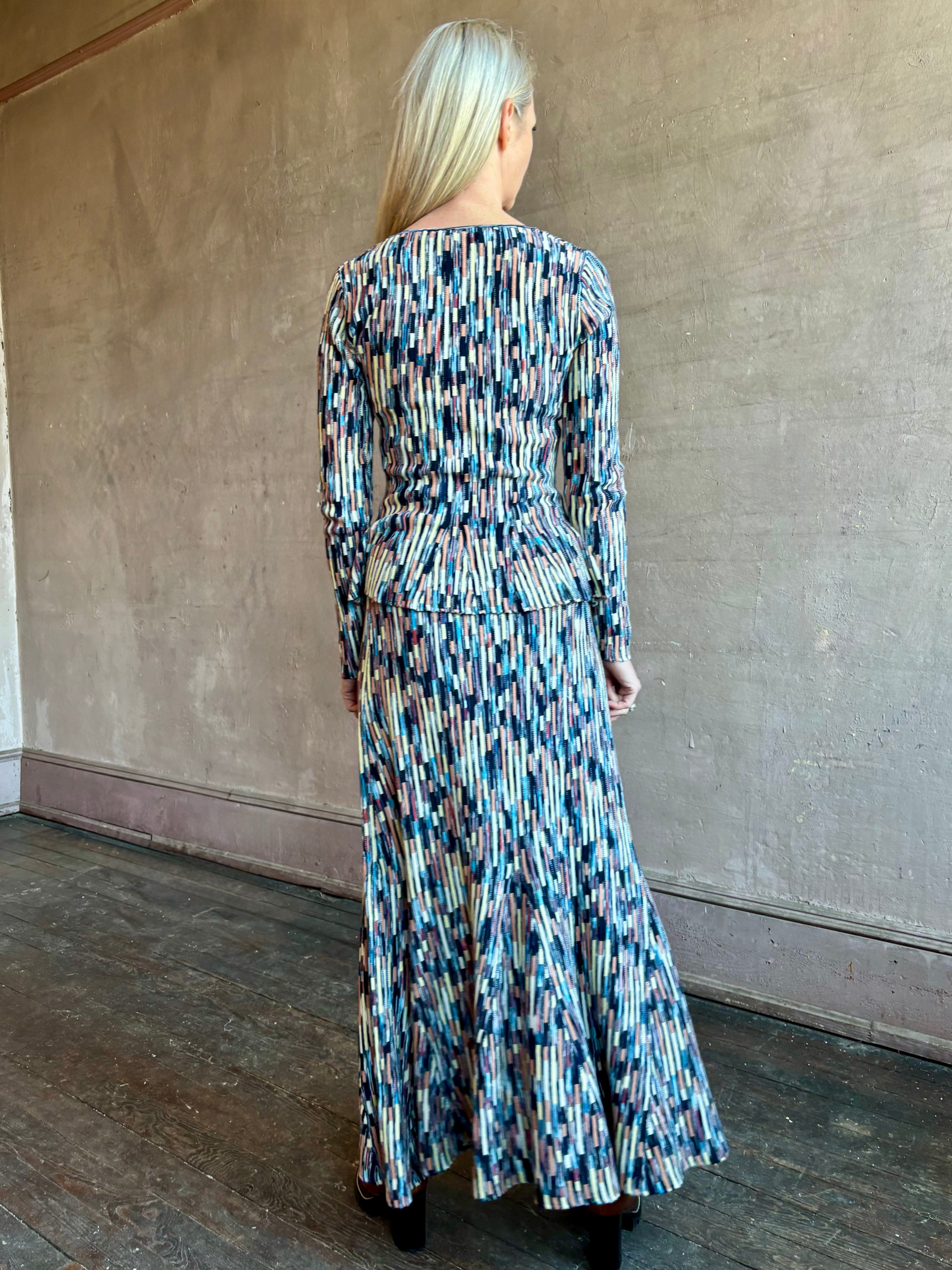 Image of woman wearing premium cotton ULLA JOHNSON Rosalia Pullover Peplum Knit Top in Oasis with matching skirt set