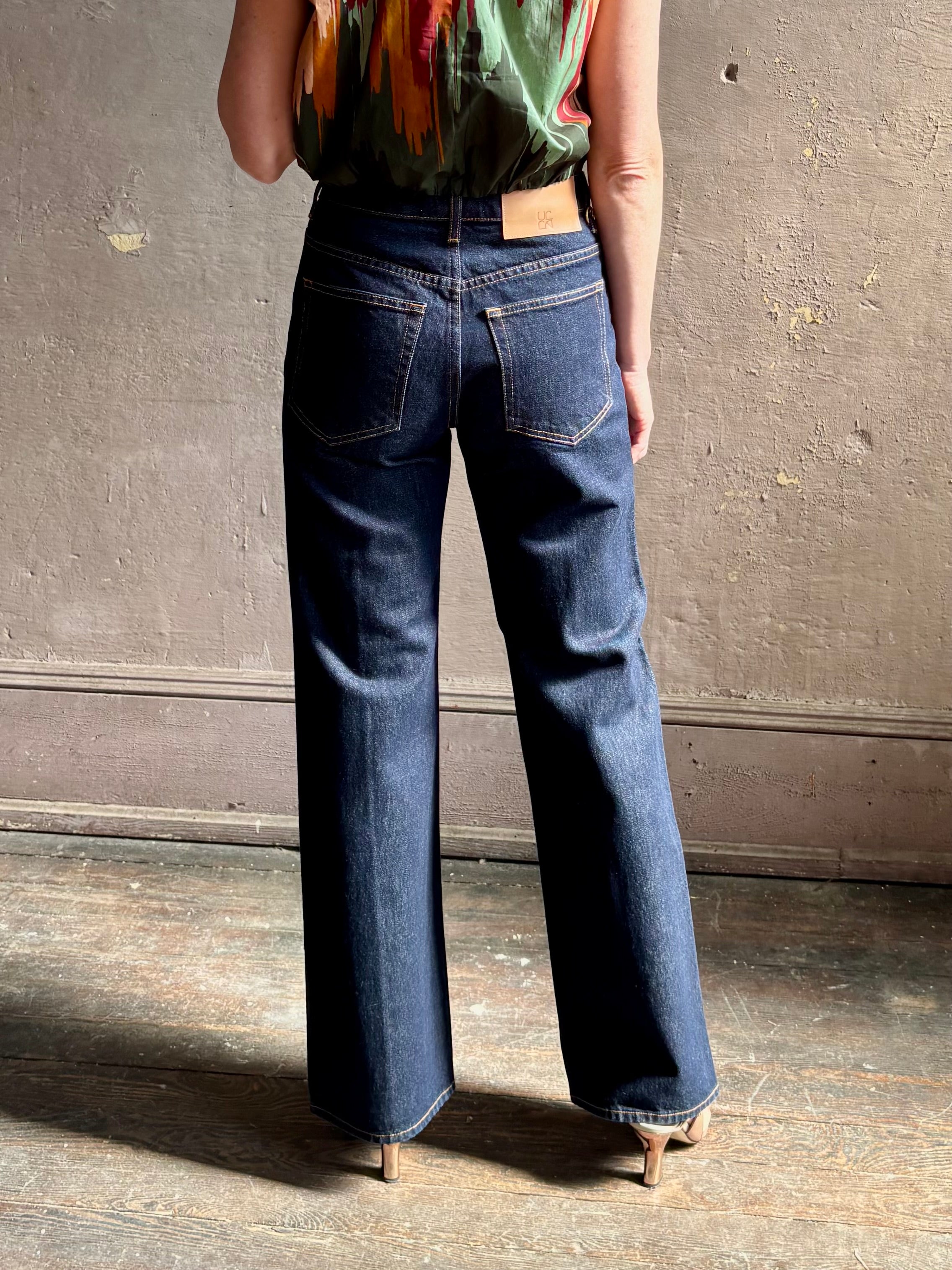 Woman wearing ULLA JOHNSON  Agatha Straight Leg Pintuck Rigid Denim jean in Tigris wash with horsebit detail
