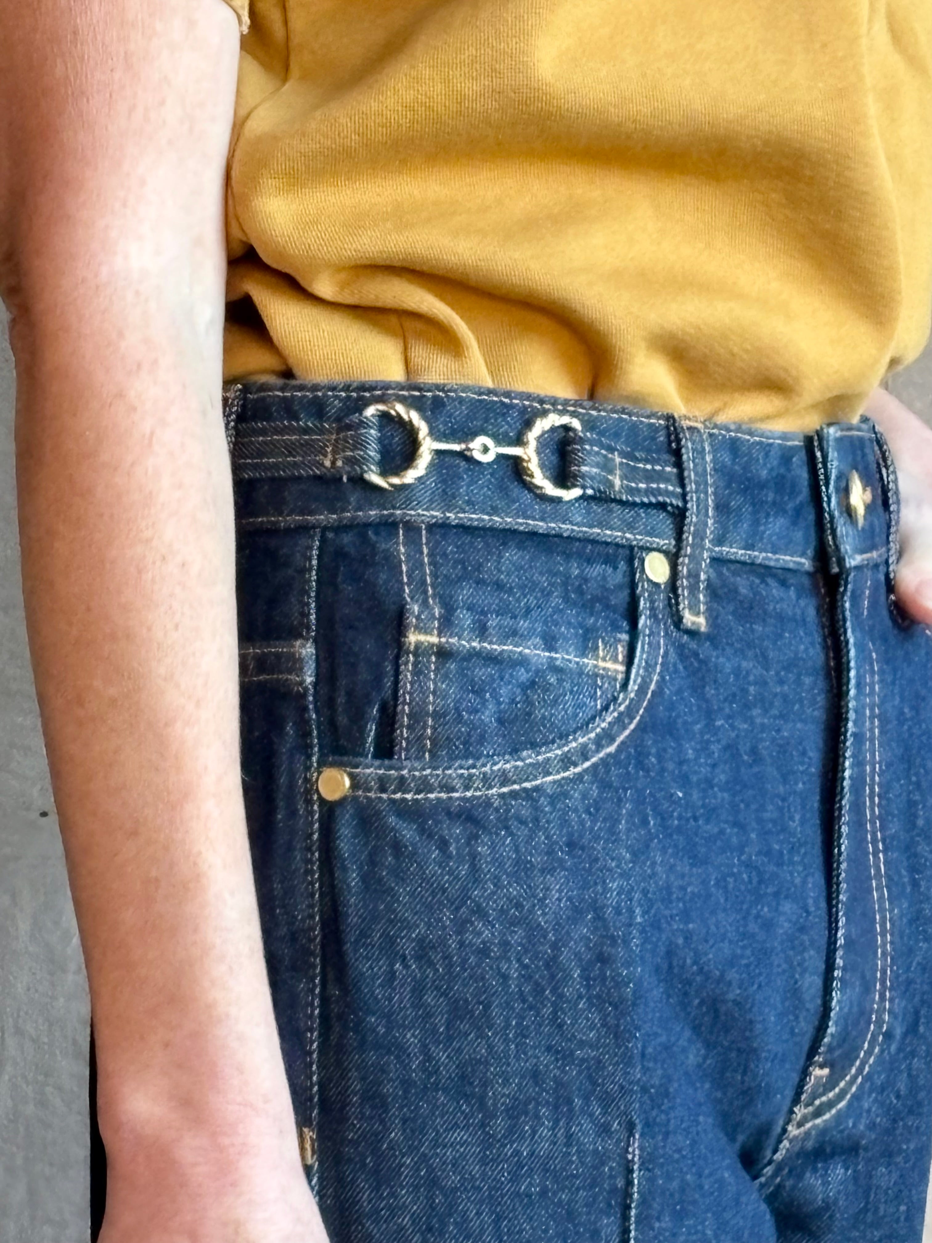 Woman wearing ULLA JOHNSON handmade Agatha Straight Leg Pintuck Rigid Denim jean in Tigris wash with horsebit detail 