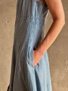 Woman wearing classic Ulla Johnson Anela midi chambray dress delicate lace details sleeveless fit and flare