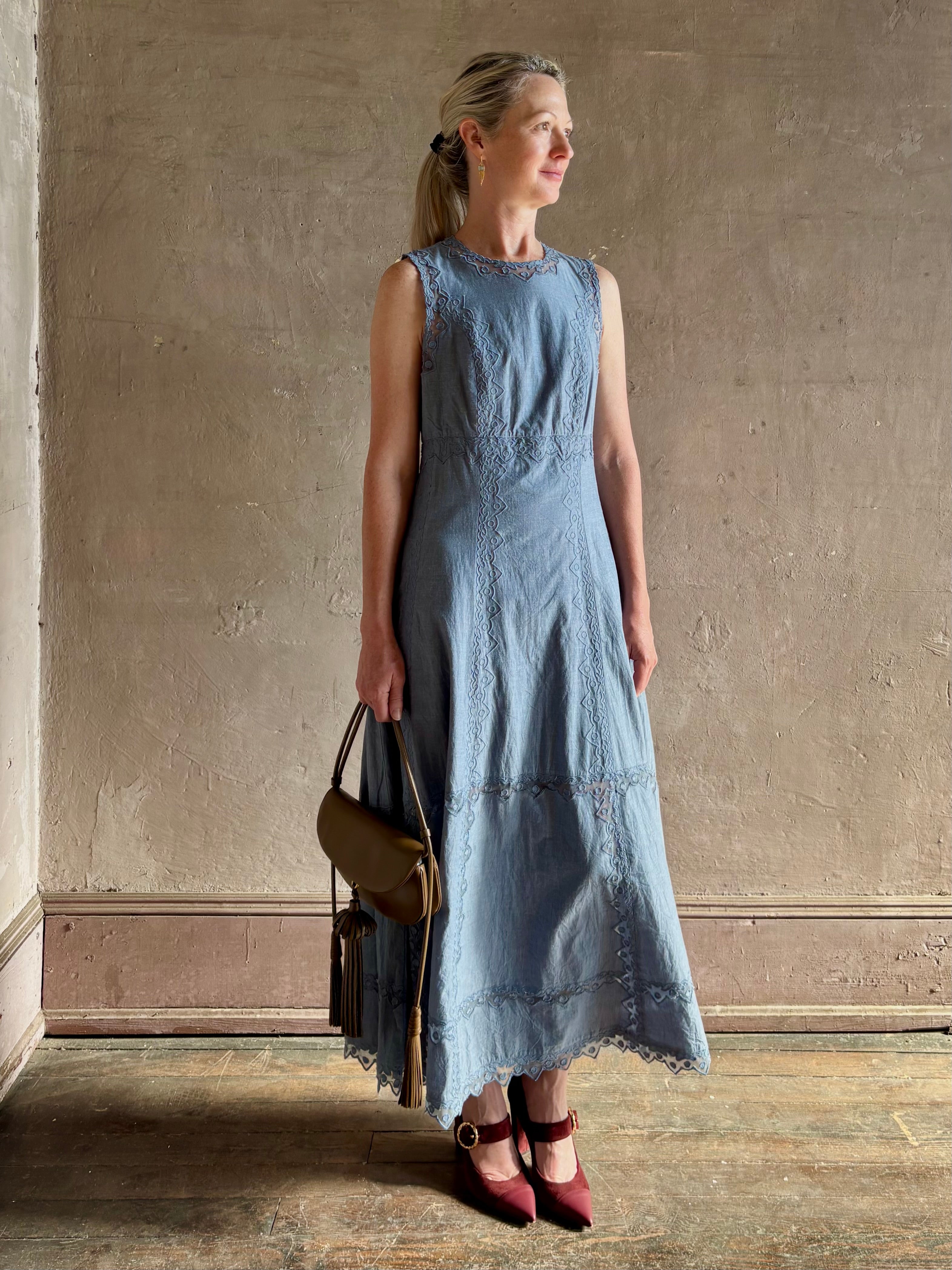 Woman wearing classic Ulla Johnson Anela midi chambray dress delicate lace details sleeveless fit and flare