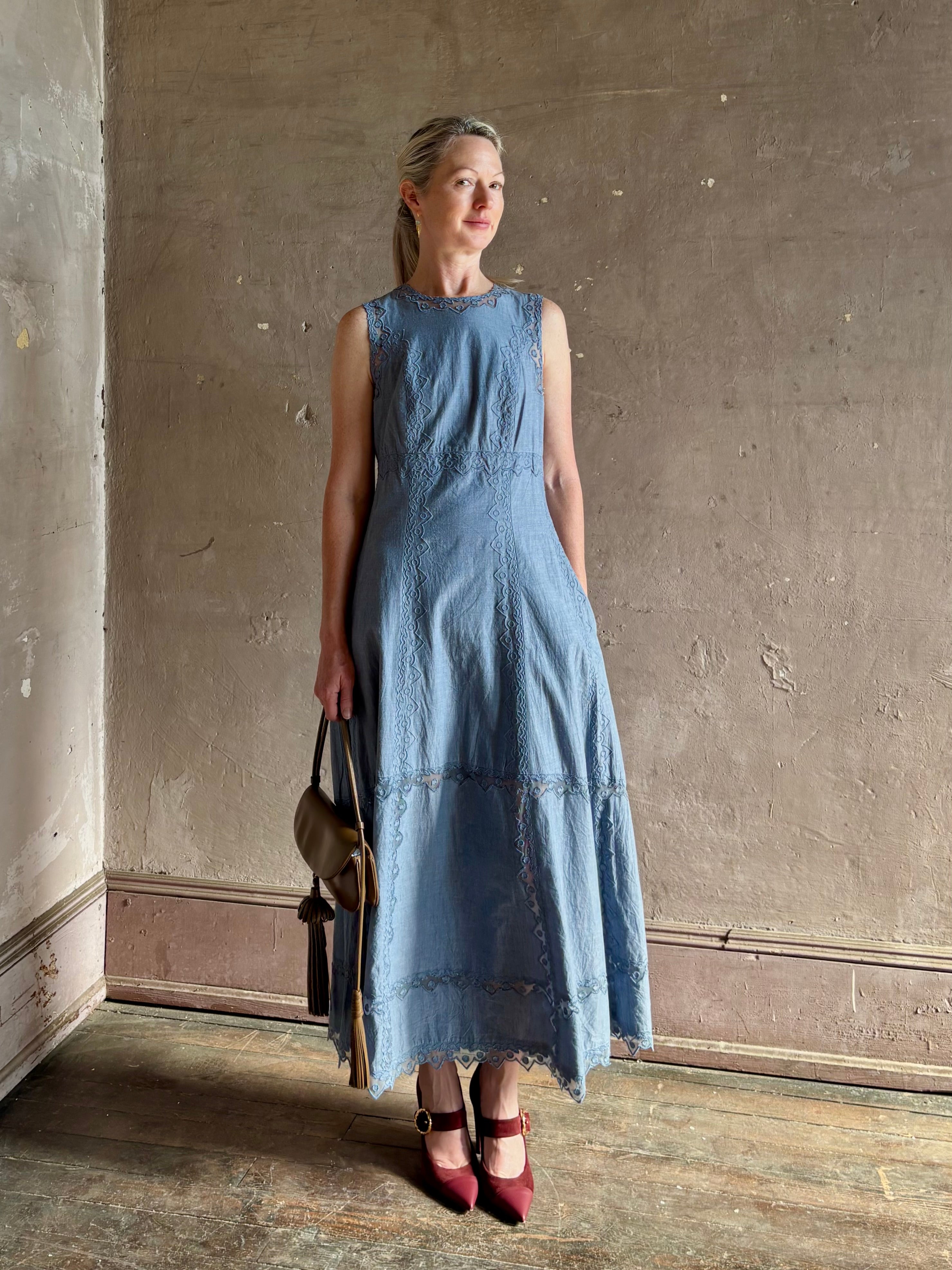 Woman wearing classic Ulla Johnson Anela midi chambray dress delicate lace details sleeveless fit and flare