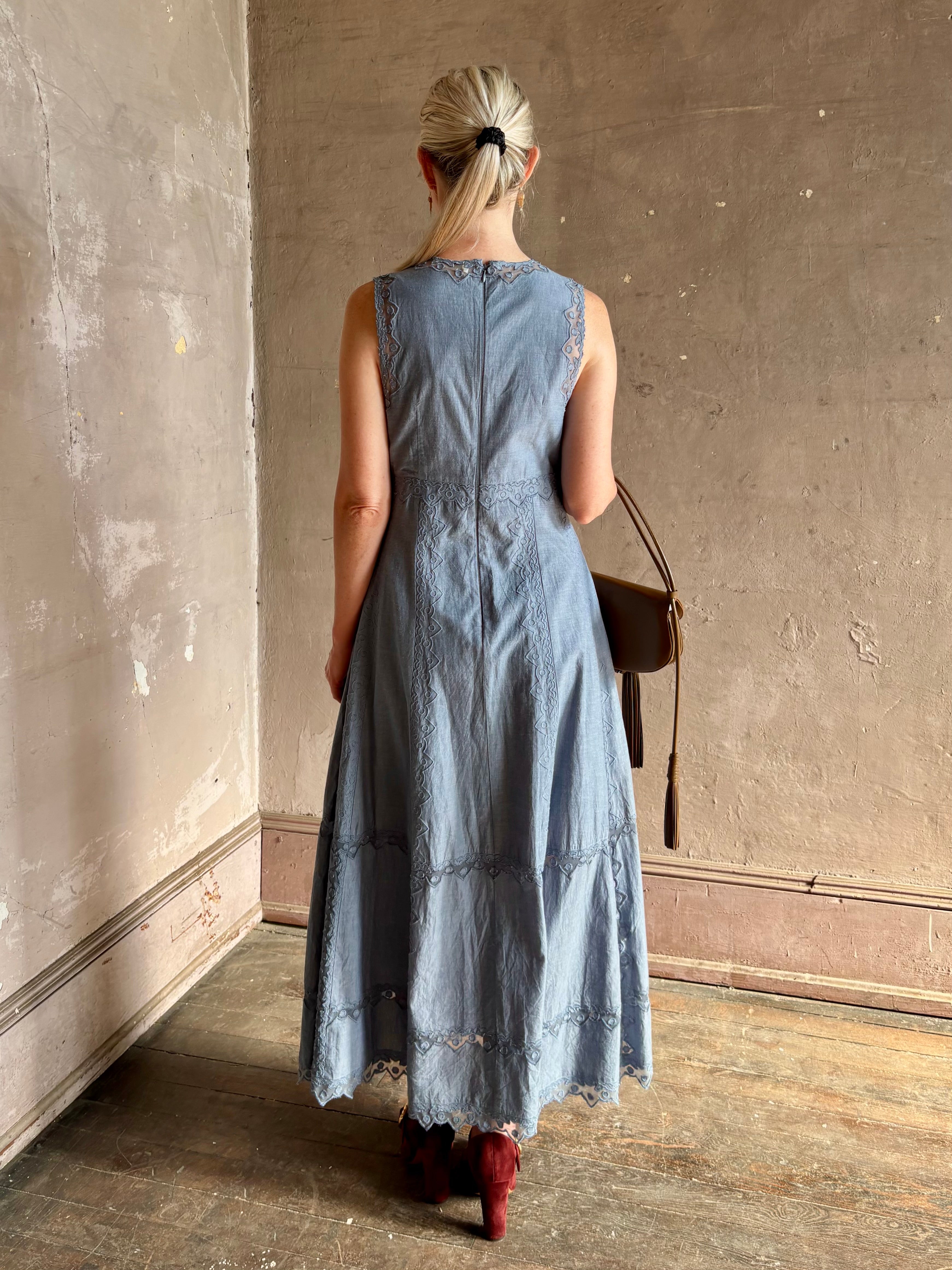 Woman wearing classic Ulla Johnson Anela midi chambray dress delicate lace details sleeveless fit and flare