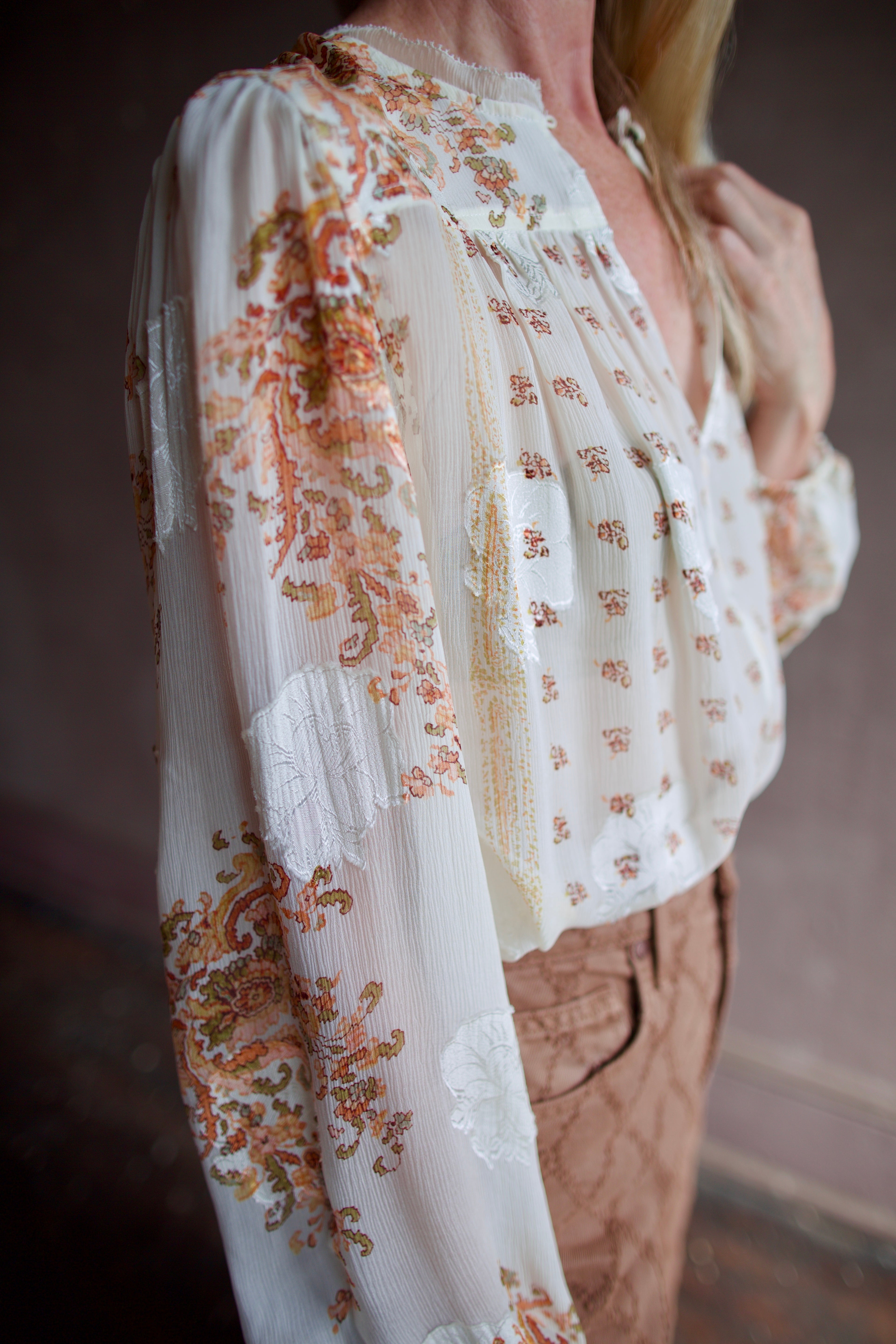 Model wearing luxury designer Ulla Johnson Aster Blouse in alabaster colorway and airy silk chiffon fabric with an elegant detailed print