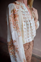 Side view image of a woman wearing the Ulla Johnson Aster Blouse and Veronica Beard Taylor Jeans