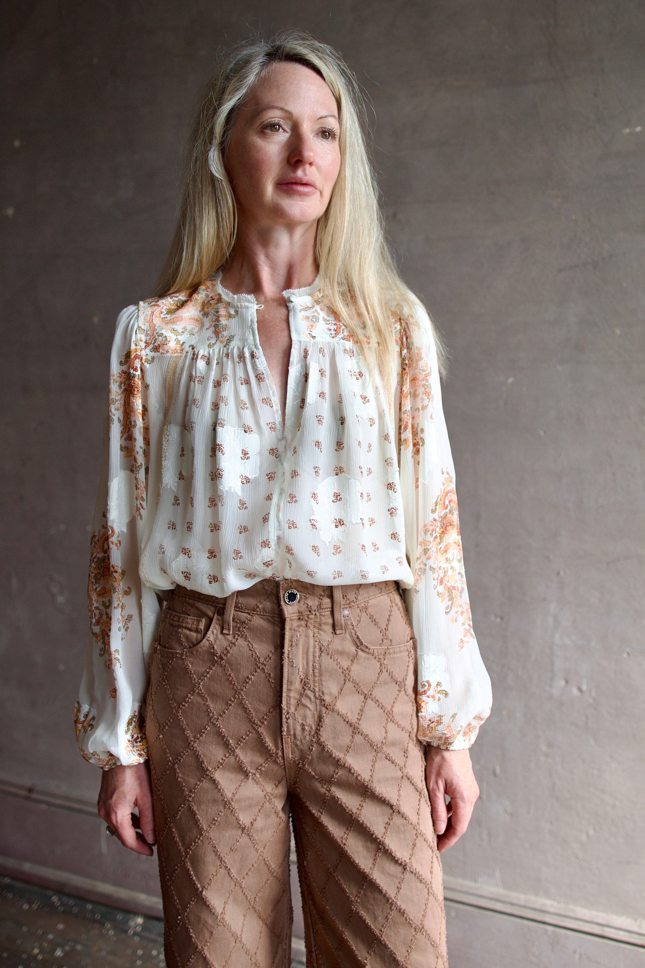 Model wearing luxury designer Ulla Johnson Aster Blouse in alabaster colorway and airy silk chiffon fabric with an elegant boho inspiration