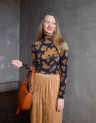 image of a woman wearing the Ulla Johnson Aurelia turtleneck, forte forte matte corduroy pants and Ulla Johnson Twyla handbag