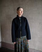 Image featuring a woman wearing the wool & cashmere Carina jacket by Ulla Johnson features a zip front and full sleeve with front pockets in navy blue.