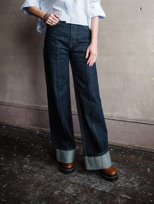 Image featuring a woman wearing Ulla Johnson Genevieve Jean with pintucking detail down middle front and back legs in a dark denim finish with no distressing.