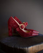 Image featuring the Kiki burgundy suede heels by Ulla Johnson with a pointed leather toe, gold finish buckle closure and a 3.5" tall block heel.