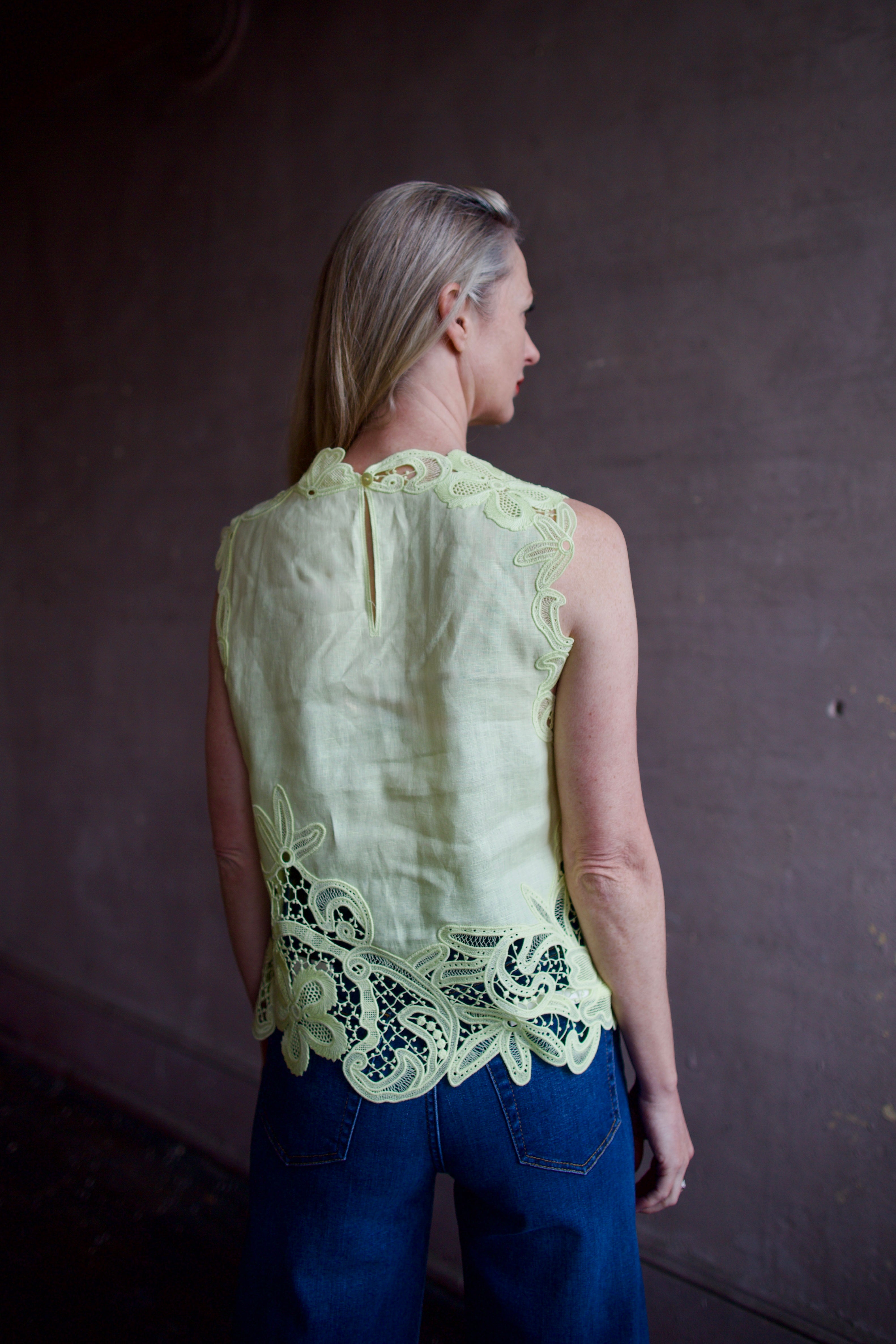 Mature woman wearing luxury designer Ulla Johnson Marlis premium linen top in citrine distinctive lace appliqué 