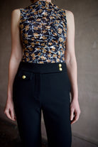 Woman wearing ulla johnson medea top  sustainable premium lyocell  flattering ruching with orange floral and tie die pattern stretch comfort fabric