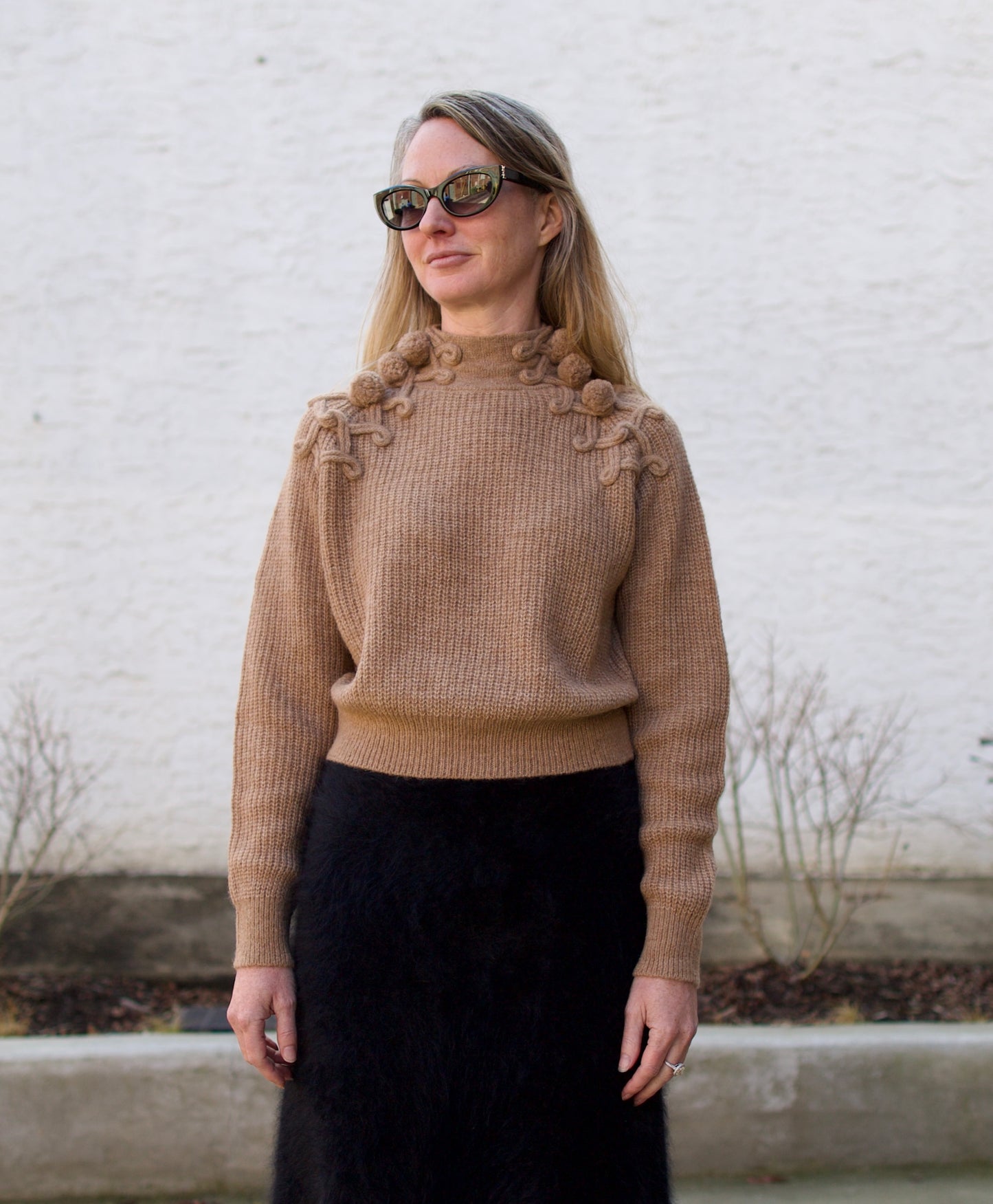 image of a woman wearing the Ulla Johnson Reina pullover and Lisa Yang brushed cashmere skirt