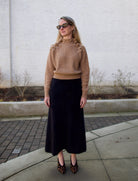 image of a woman wearing the Ulla Johnson Reina pullover and Lisa Yang brushed cashmere skirt with the Ulla Johnson Polline Pumps