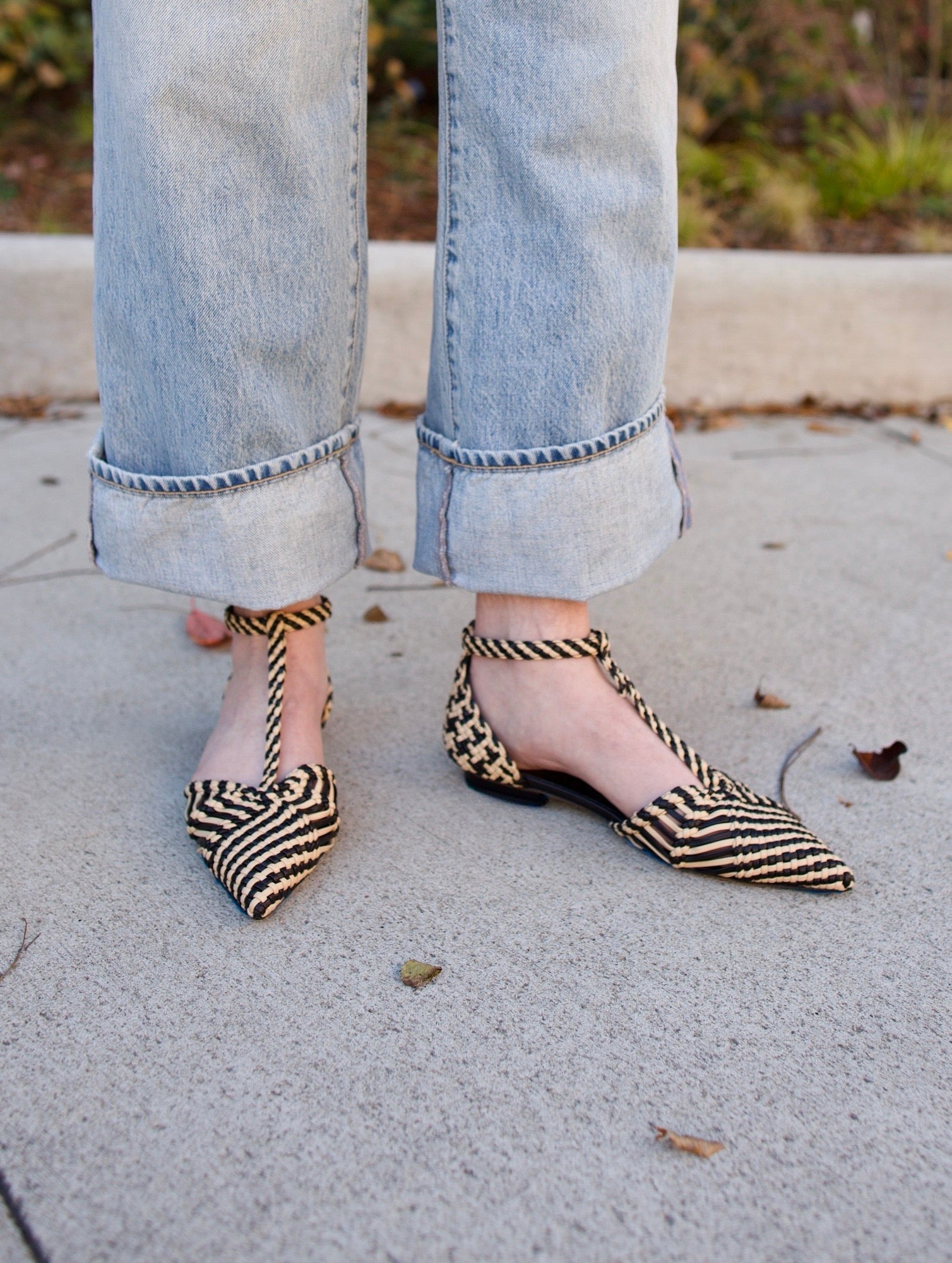 Ulla Johnson's Daria Flats in Black/Tan — hand-woven vegan leather with a pointed toe and T-strap. Textural, artisan-crafted everyday elegance.