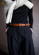 Mature woman wearing Ulla Johnson gia leather belt with gold finish twist buckle in Sierra brown