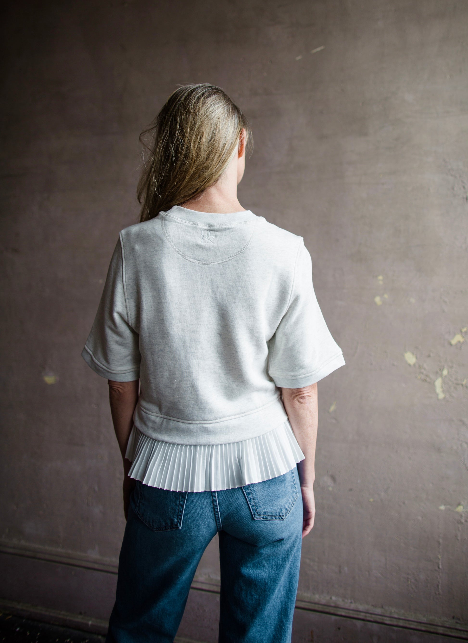 Image of the back of a woman wearing the Ulla Johnson Harper Top and the Re/Done 90's High rise Loose Jeans