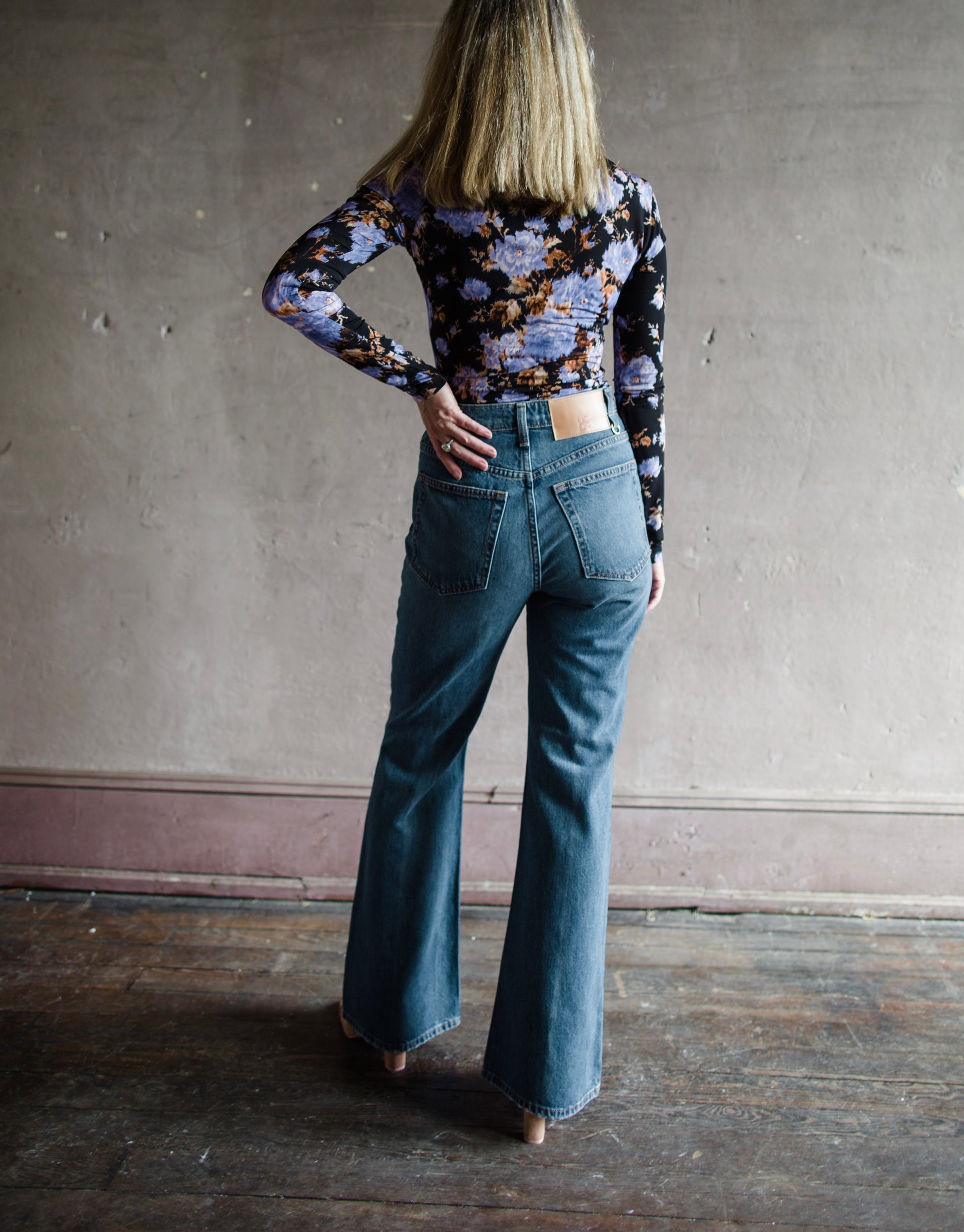 Image featuring a woman wearing the Lou jeans by Ulla Johnson with a high rise button fly, front patch pockets and a slightly flared hem in Danube wash.