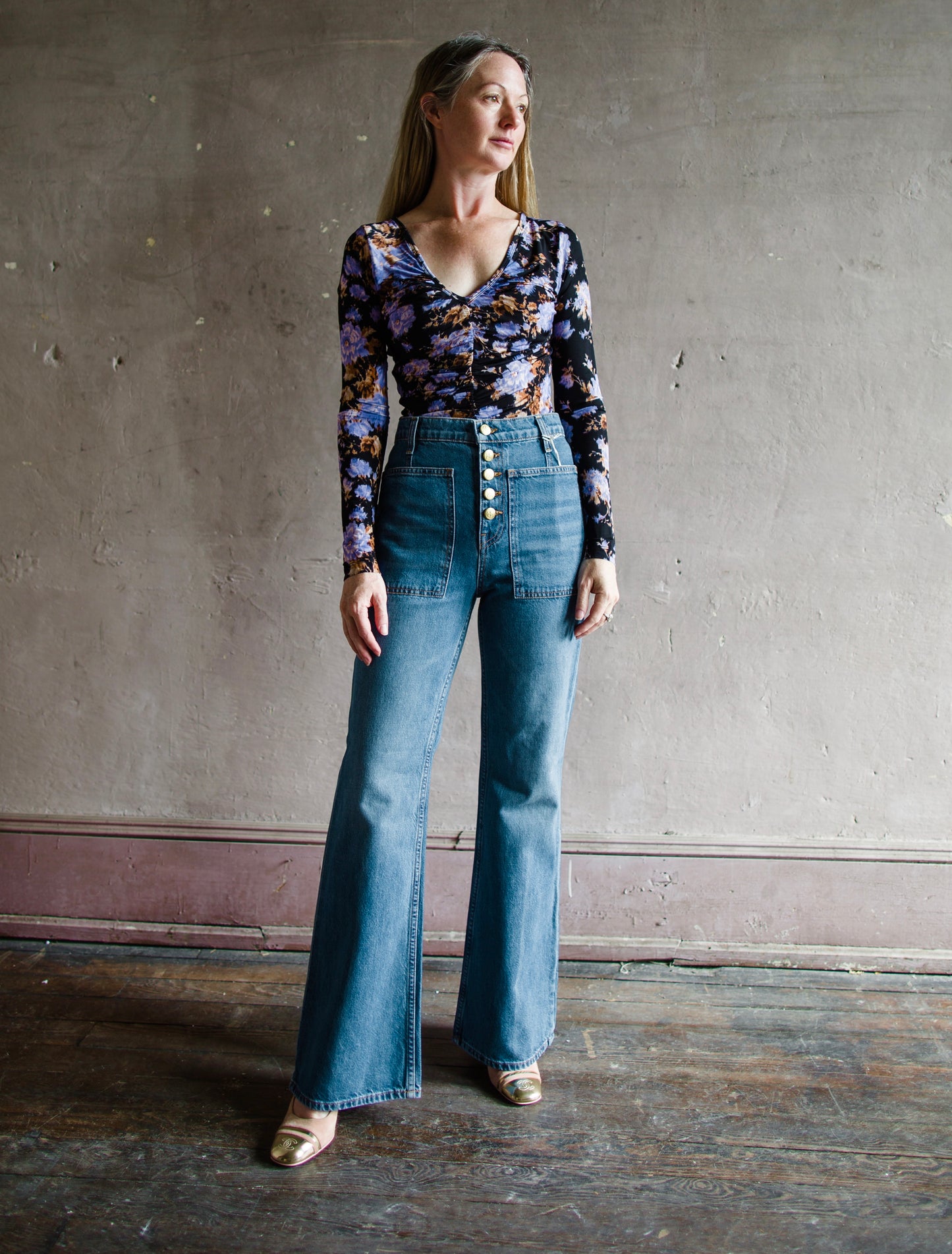 Image featuring a woman wearing the Lou jeans by Ulla Johnson with a high rise button fly, front patch pockets and a slightly flared hem in Danube wash.