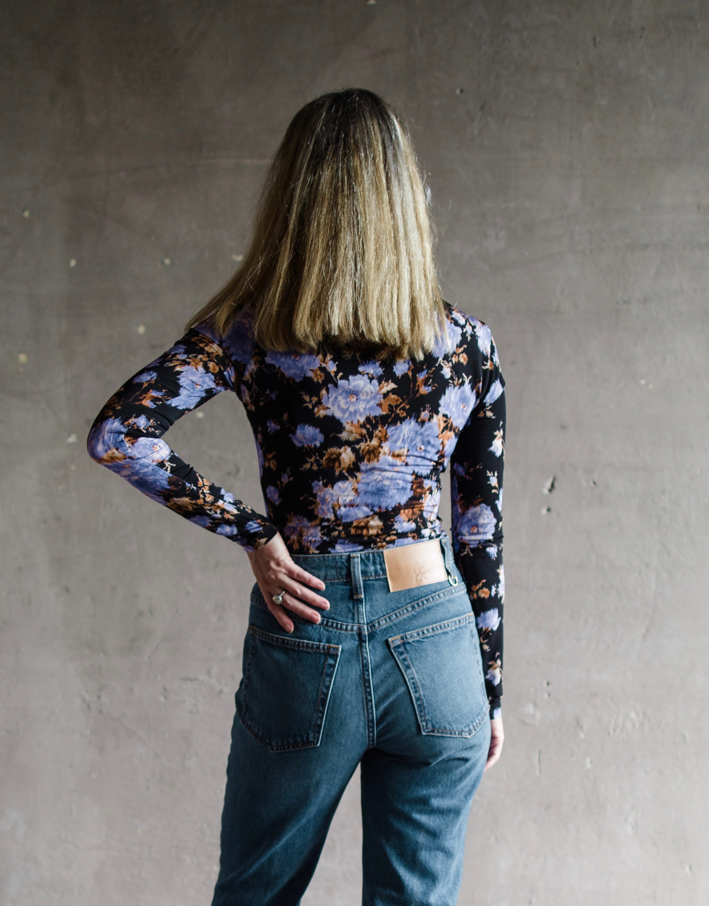 Image featuring a woman wearing the Tasia top by Ulla Johnson with a v neckline and ruched bust with an allover floral print.