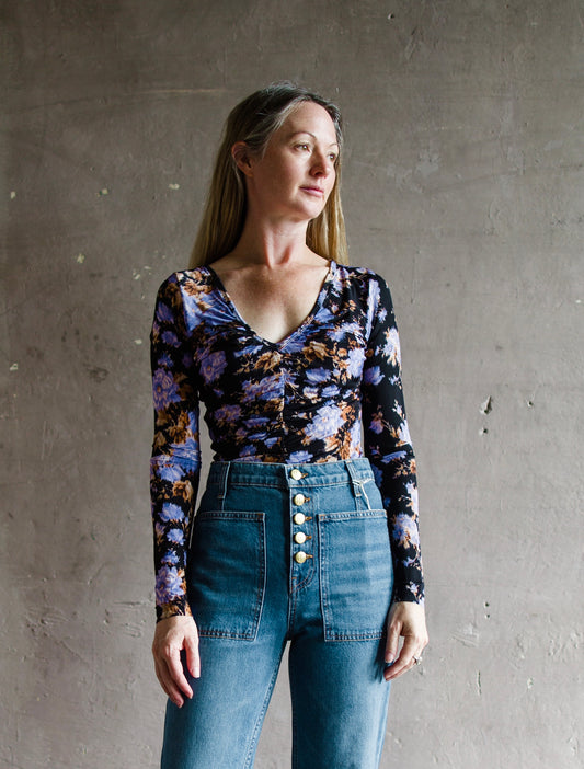 Image featuring a woman wearing the Tasia top by Ulla Johnson with a v neckline and ruched bust with an allover floral print.