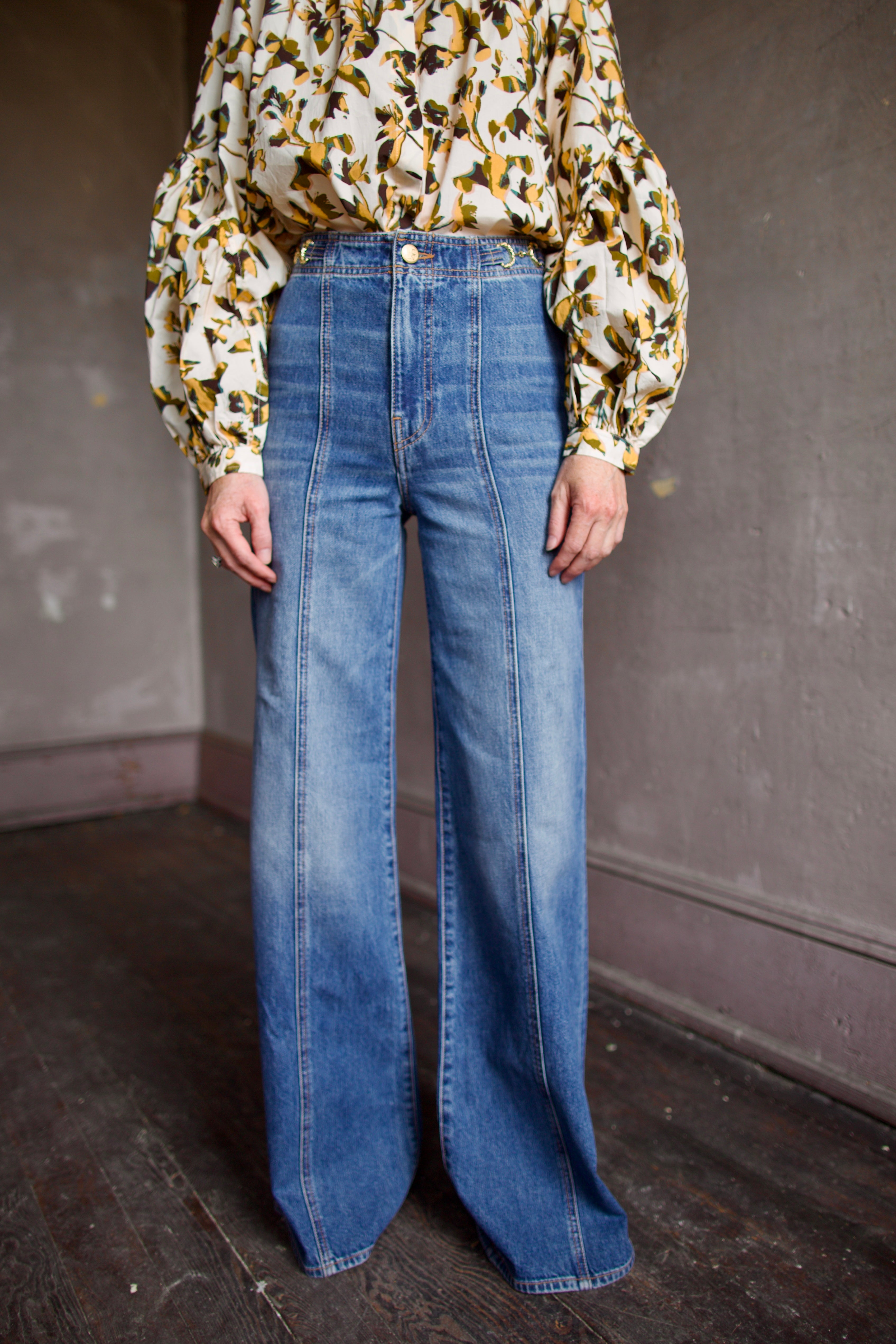 Model wearing a floral blouse and expertly designed blue flared denim by New York designer Ulla Johnson