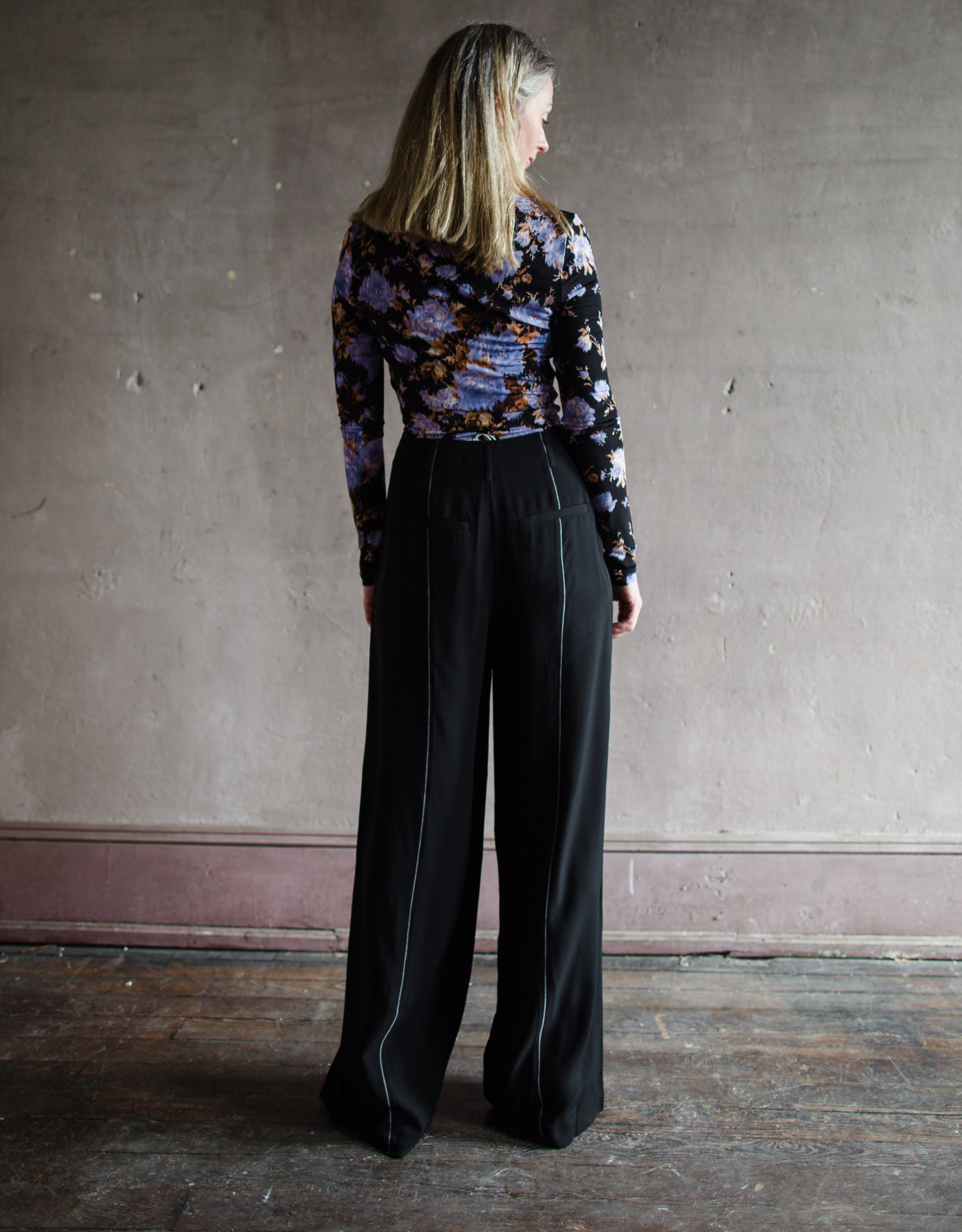 Image featuring a woman wearing the Delvine pants by Ulla Johnson feature a high rise with contrasting seam details in black.