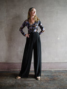 Image featuring a woman wearing the Delvine pants by Ulla Johnson feature a high rise with contrasting seam details in black.