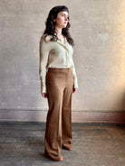 Image of woman wearing premium wool tailored blanca trousers by luxury designer Ulla Johnson Blanca in a neutral medium brown