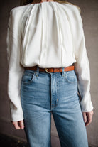 Mature woman wearing Ulla Johnson Kavi long sleeve Blouse with three dimensional linear details crew neck hidden closure