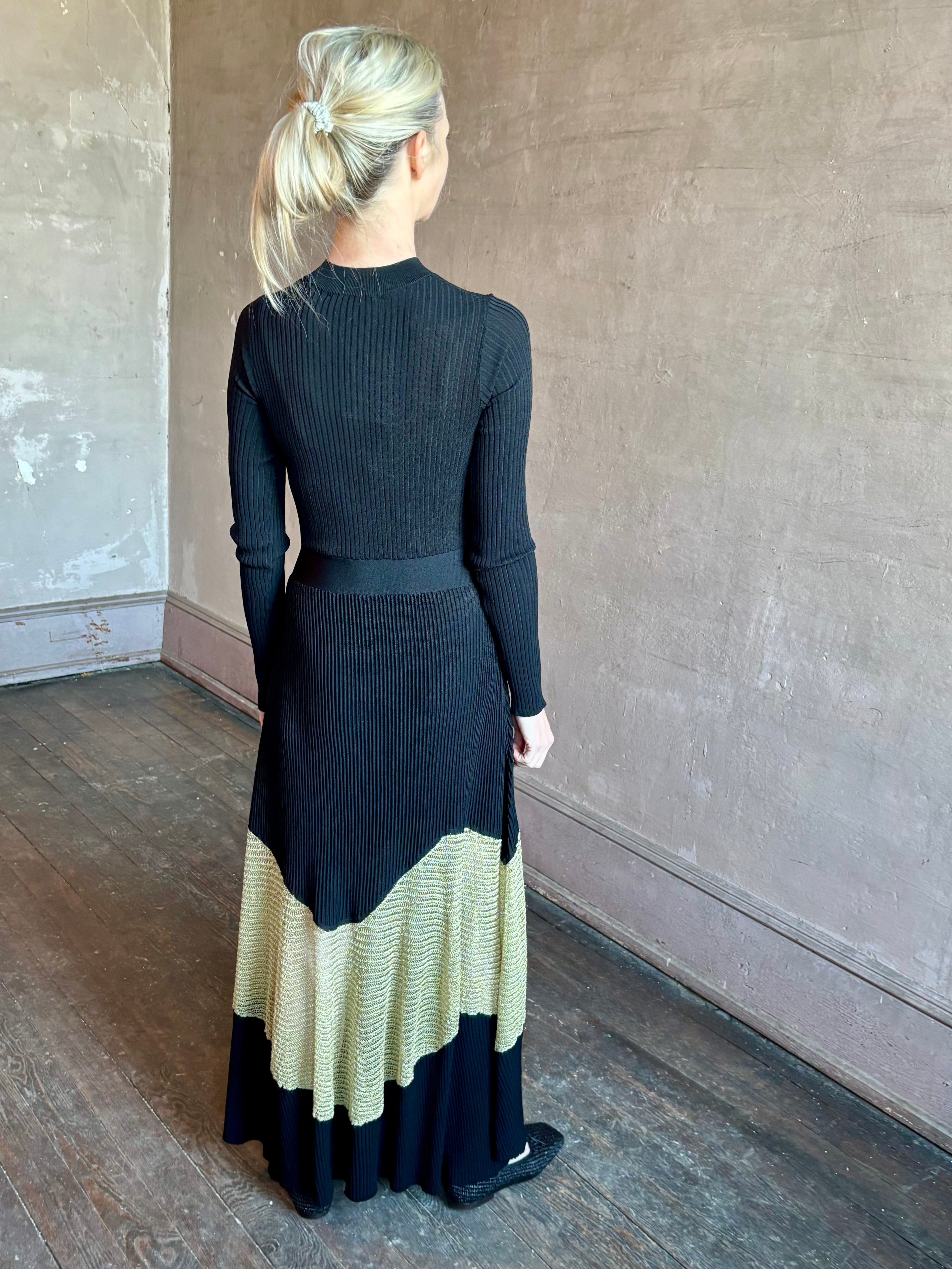 Image of woman wearing sophisticated Ulla Johnson Roanne knit maxi A-Line Dress with elegant sheer gold chevron detail and long sleeves
