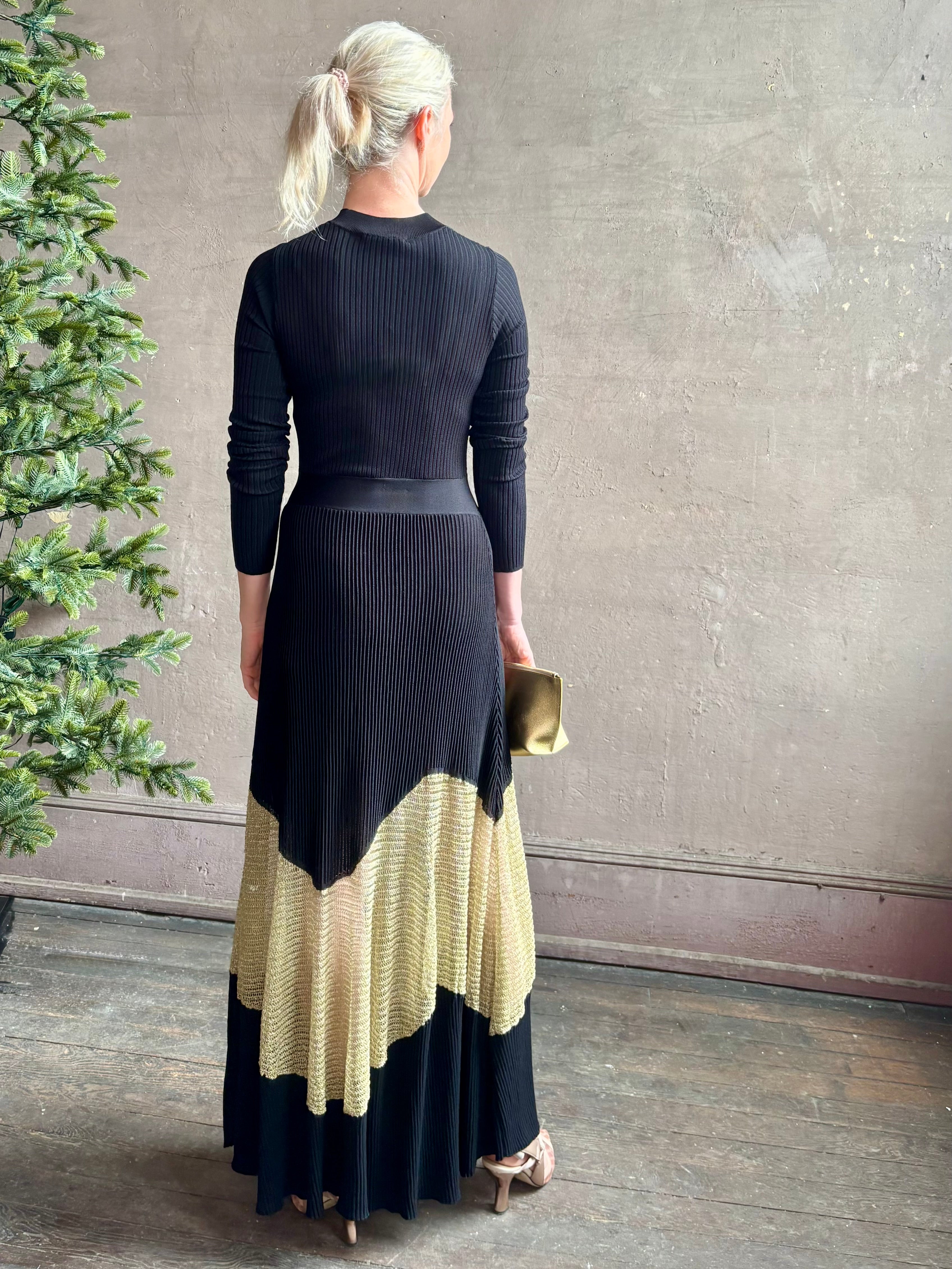 Image of woman wearing sophisticated Ulla Johnson Roanne knit maxi A-Line Dress with elegant sheer gold chevron detail and long sleeves