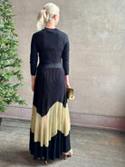 Image of woman wearing sophisticated Ulla Johnson Roanne knit maxi A-Line Dress with elegant sheer gold chevron detail and long sleeves