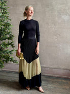 Image of woman wearing sophisticated Ulla Johnson Roanne knit maxi A-Line Dress with elegant sheer gold chevron detail and long sleeves