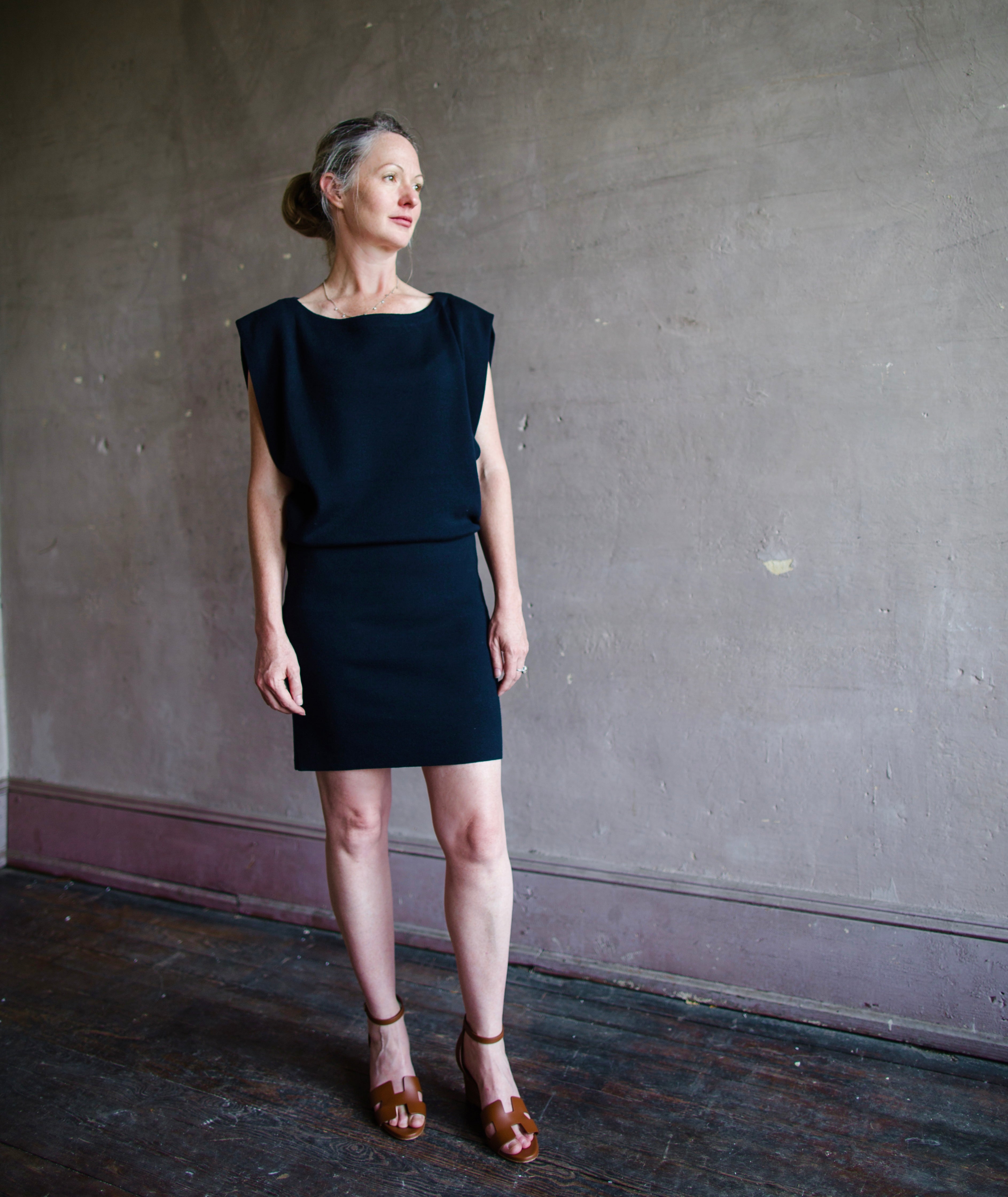 Mature woman wearing the Dorotea dress by Vanessa Bruno with boatneck blouson top fitted skirt in navy blue.
