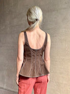 Mature woman wearing the Charlie Top from designer Veronica Beard rendered in dark brown with white contrast stitching and crafted from a cotton blend this peplum offers a flattering silhouette that's sleeveless with a scoop neckline in front and back along with a convenient concealed zip closure