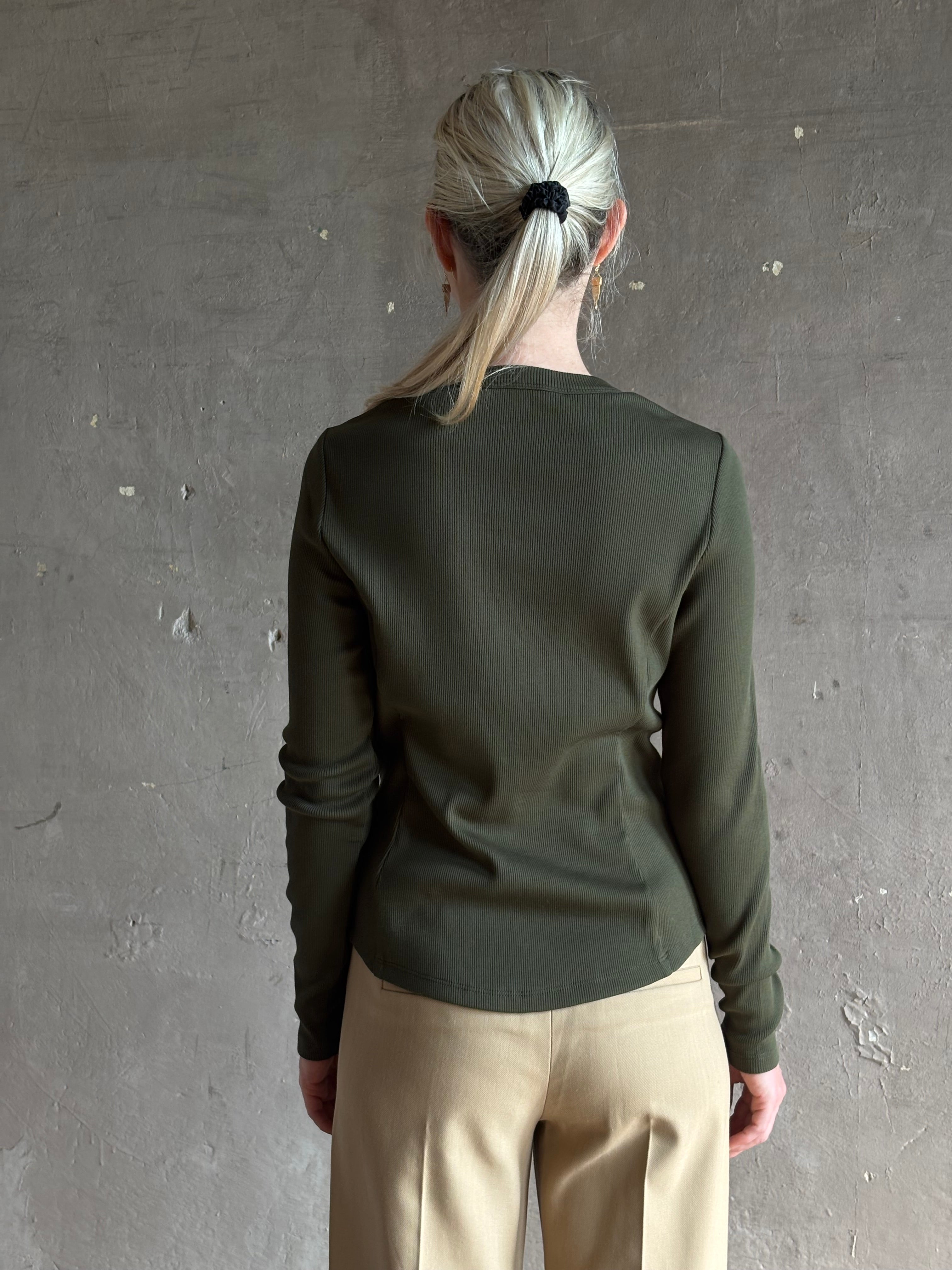 Mature womanwearing a dark green long-sleeve ribbed cotton henley top designer Veronica Beard Cordis Long Sleeves