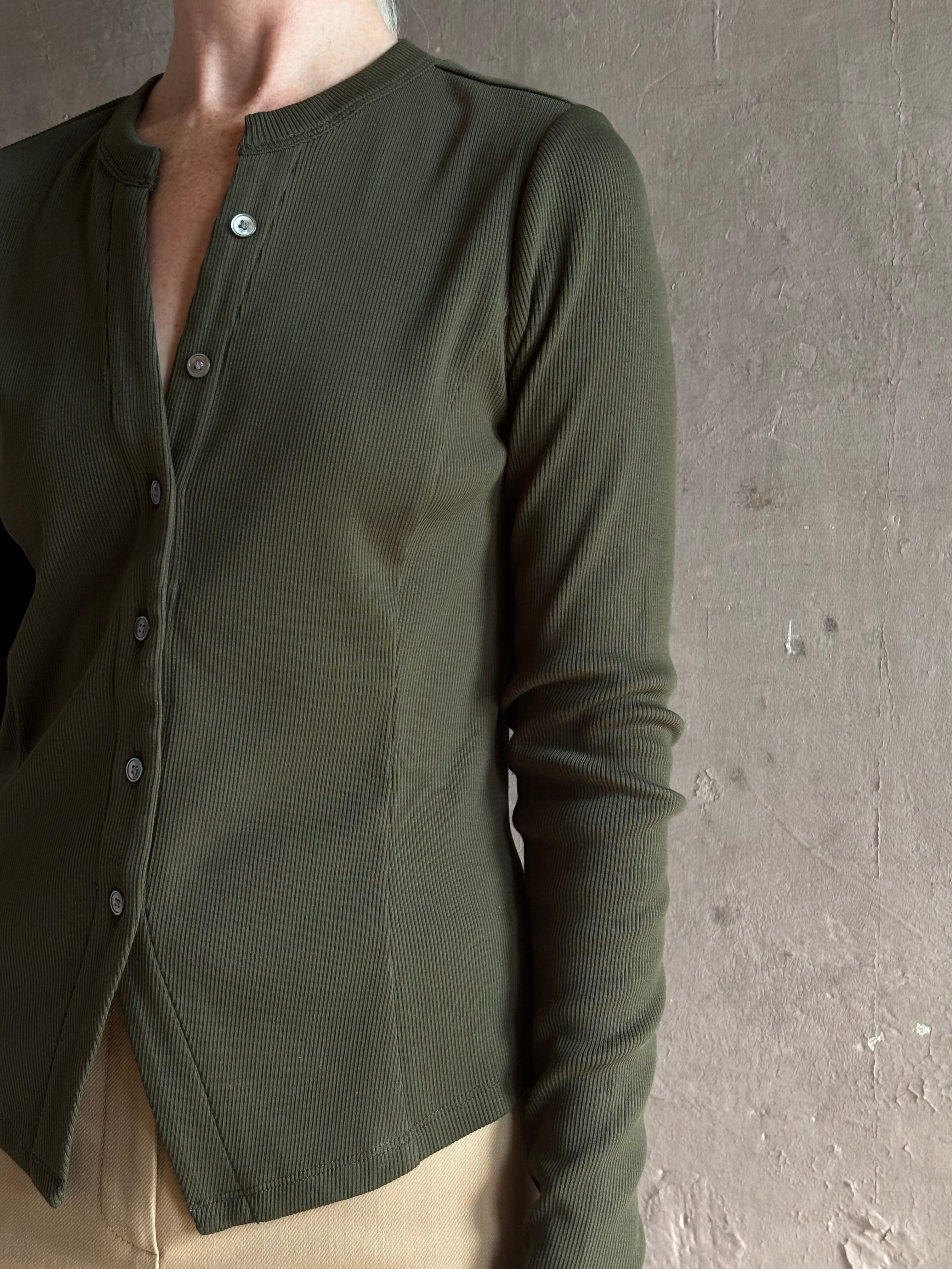 Mature womanwearing a dark green long-sleeve ribbed cotton henley top designer Veronica Beard Cordisv-neck
