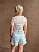 Mature woman wearing elevated Craig Short from Veronica Beard a sophisticated women's designer short rendered in river mist light blue and crafted from a refined blend of cotton and viscose with side pockets, one front pleat and tailored waistband with belt loops