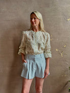 Mature woman wearing elevated Craig Short from Veronica Beard a sophisticated women's designer short rendered in river mist light blue and crafted from a refined blend of cotton and viscose with side pockets, one front pleat and tailored waistband with belt loops