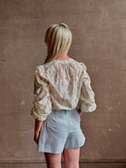 Mature woman wearing elevated Craig Short from Veronica Beard a sophisticated women's designer short rendered in river mist light blue and crafted from a refined blend of cotton and viscose with side pockets, one front pleat and tailored waistband with belt loops