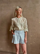 Mature woman wearing elevated Craig Short from Veronica Beard a sophisticated women's designer short rendered in river mist light blue and crafted from a refined blend of cotton and viscose with side pockets, one front pleat and tailored waistband with belt loops