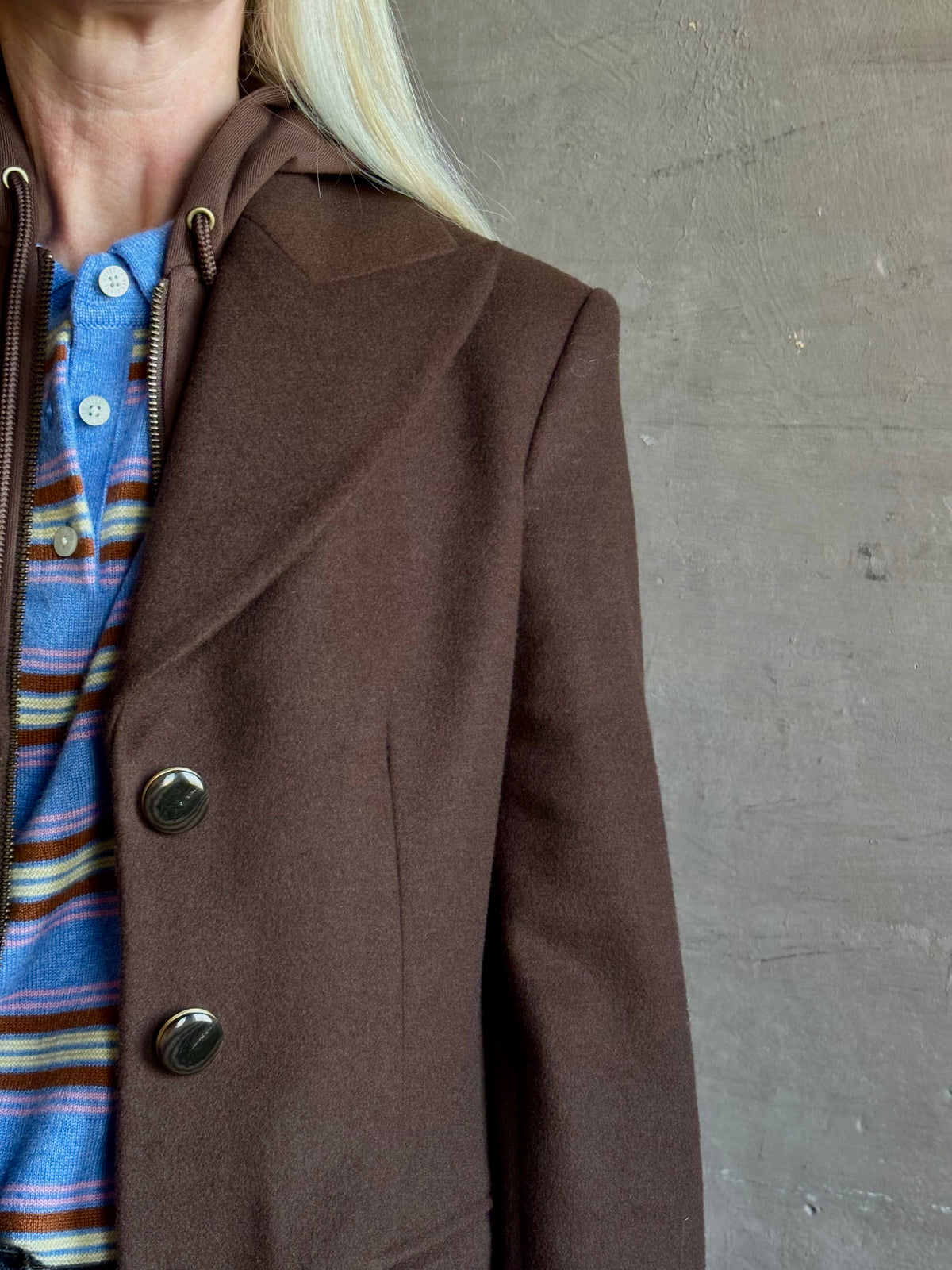 Mature woman wearing Veronica Beard Elspeth Coat with OVS Hoodie Dickey in Espresso brown wool-cashmere A-line coat with a removable hoodie layer. Playful, sculptural cold-weather luxury.