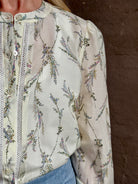 Mature woman wearing luxurious tailored Emiko Blouse from Veronica Beard a women's designer blouse rendered in a cream  ground adorned with a delicate prairie floral print and crafted from a cotton and silk blend with long sleeves, button front and round mandarin collar.