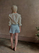 Mature woman wearing luxurious tailored Emiko Blouse from Veronica Beard a women's designer blouse rendered in a cream  ground adorned with a delicate prairie floral print and crafted from a cotton and silk blend with long sleeves, button front and round mandarin collar.