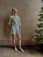 Mature woman wearing luxurious tailored Emiko Blouse from Veronica Beard a women's designer blouse rendered in a cream  ground adorned with a delicate prairie floral print and crafted from a cotton and silk blend with long sleeves, button front and round mandarin collar.