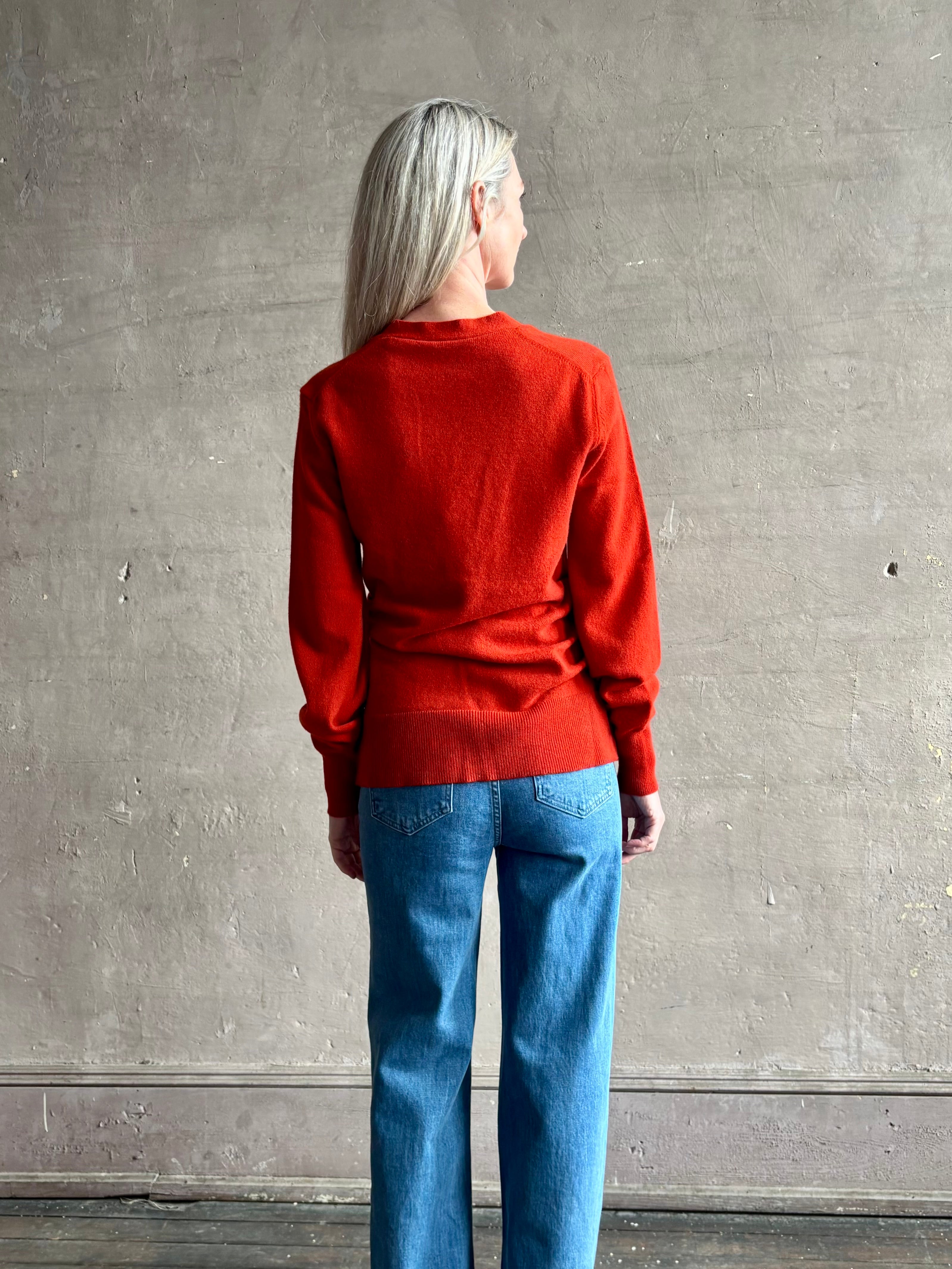 Woman wearing VERONICA BEARD Lamotte Cashmere Cardigan in a orange Red with long sleeves